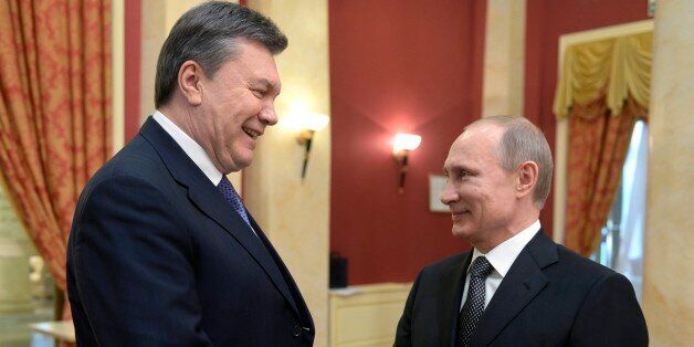 FILE - A Friday, Feb. 7, 2014 photo from files showing Russian President Vladimir Putin, right, shaking hands with Ukrainian President Viktor Yanukovych at the Olympic reception hosted by the Russian President in Sochi, Russia. Russia questioned the legitimacy of the new Ukrainian authorities on Monday, Feb. 24, 2014, with its prime minister saying it sees the turmoil in Ukraine as a threat to both Russian citizens and Russian interests in Ukraine. (AP Photo/RIA-Novosti, Alexei Nikolsky, Presidential Press Service, Pool, File)