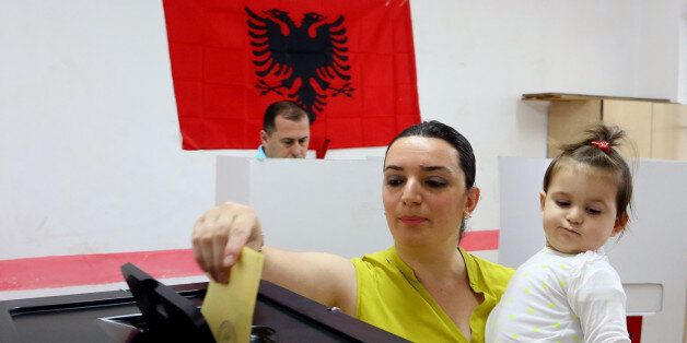 An Albanian casts her ballot for the local municipal elections, a key step in the countryâs efforts to launch membership negotiations with the European Union, in Tirana, Sunday, June 21, 2015. Some 3.4 million eligible voters cast their ballots in the country's seventh local polls since the fall of communism in 1990 to elect 61 mayors and 1,595 municipal counsellors. (AP Photo/Hektor Pustina)