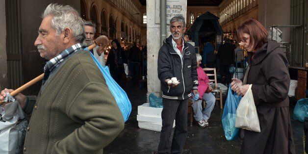 A man sells garlic on March 4, 2015 at a market in the center of Athens central market. Greece on March 4 raised 1.138 billion euros ($1.29 billion) in six-month treasury bills as it raced to gather funds for debt repayments this month, but paid higher rates. Greece needs to find over 6.0 billion euros by the end of the month to redeem maturing treasury bills and repay loans received from the International Monetary Fund. AFP PHOTO / LOUISA GOULIAMAKI (Photo credit should read LOUISA G