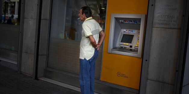 A man puts his wallet in his pocket after withdrawing euro notes from a bank machine in Athens, Thursday, June 25, 2015. The ECB approved a request from Athens to increase the amount of emergency liquidity Greek lenders can tap from the country's central bank. Worried Greeks have been withdrawing their money from their country's banks, fearing the imposition of restrictions on banking transactions. An estimated more than 4 billion euros ($4.5 billion) left Greek banks last week. (AP Photo/Daniel Ochoa de Olza)