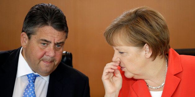 German Chancellor Angela Merkel, right, and Vice-Chancellor Sigmar Gabriel, left, talk at the beginning of the weekly cabinet meeting at the chancellery in Berlin, Germany, Wednesday, May 13, 2015. (AP Photo/Michael Sohn)