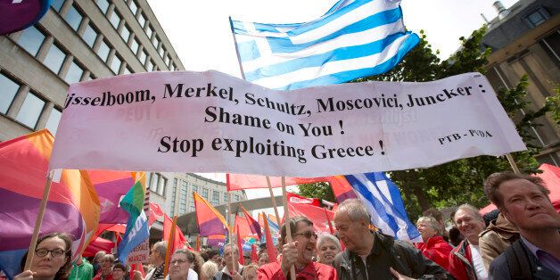 Demonstrators hold flags and banners during a protest march in solidarity with Greece in the center of Brussels on Sunday, June 21, 2015. Heads of state in the eurogroup will meet in Brussels on Monday for a special summit to discuss the financial crisis with Greece. (AP Photo/Virginia Mayo)