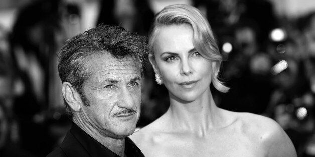 US actor Sean Penn (L) and his partner South African-US actress Charlize Theron pose as they arrive for the screening of the film 'Mad Max : Fury Road' during the 68th Cannes Film Festival in Cannes, southeastern France, on May 14, 2015. AFP PHOTO / VALERY HACHE (Photo credit should read VALERY HACHE/AFP/Getty Images)