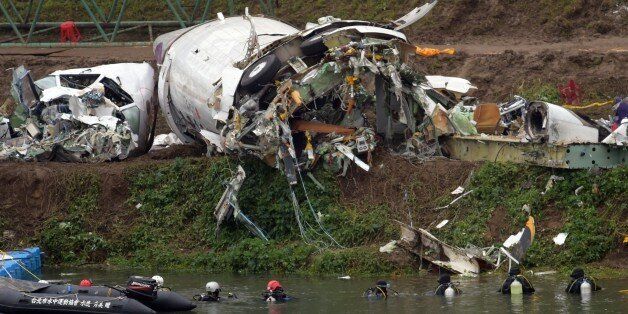 A general view shows divers searching the Keelung river for the remains of Transasia plane which crashed in New Taipei City on February 5, 2015. Taiwan rescuers scoured a river for 12 people still missing from a TransAsia plane crash as the pilot was hailed as a hero for apparently battling to avoid hitting built-up areas shortly after issuing a 'mayday' call. AFP PHOTO / Sam Yeh (Photo credit should read SAM YEH/AFP/Getty Images)
