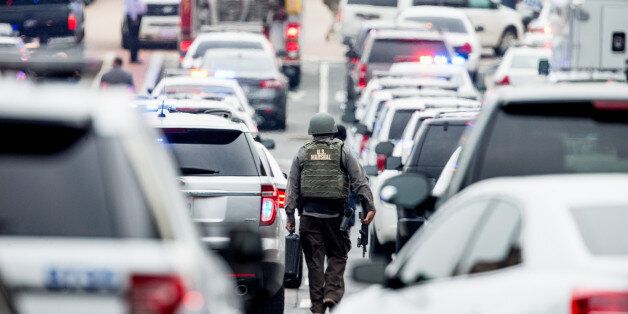 A large police presence gathers along M St. in Southeast Washington, Thursday, July 2, 2015, after an official said shots have been reported in a building on the Washington Navy Yard campus. (AP Photo/Andrew Harnik)
