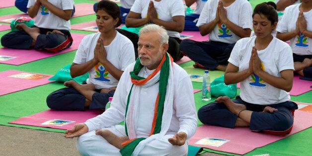 Indian Prime Minister Narendra Modi, center front, performs yoga along with thousands of Indians on Rajpath, in New Delhi, India, Sunday, June 21, 2015. Millions of yoga enthusiasts are bending their bodies in complex postures across India as they take part in a mass yoga program to mark the first International Yoga Day. (AP Photo/ Manish Swarup)