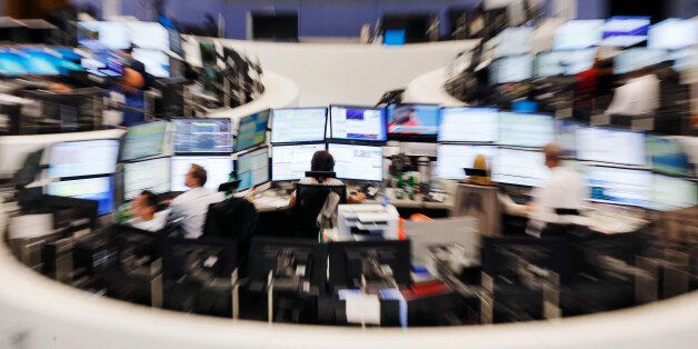 Traders sit in front of their screens at the stock market in Frankfurt, Germany, Monday, June 29, 2015. The German stock index DAX lost around 500 point right after the opening of the stock market. (AP Photo/Michael Probst)