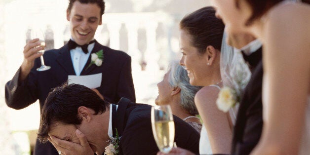 Best man making a speech on the head table at a wedding reception