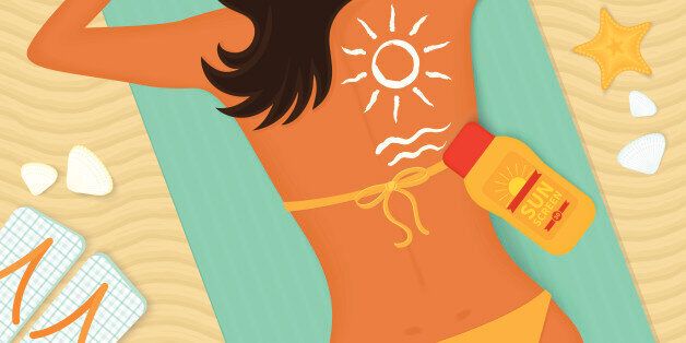 Young girl sunbathes on a beach and caring about her health she uses sunscreen