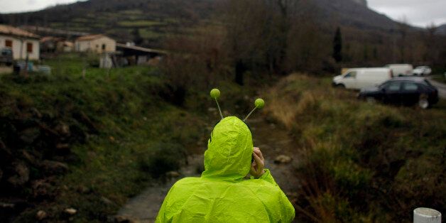 A woman dressed in an alien costume attends a small party in the town of Bugarach, France, Friday, Dec. 21, 2012. Although the long expected end of the Mayan calendar has come, the New Age enthusiasts have steered clear from the sleepy French town of Bugarach, which gave some locals a chance to joke about the UFO legends that surround the area. (AP Photo/Marko Drobnjakovic)