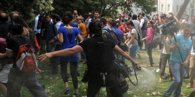 Turkish riot policemen clash on May 28, 2013with demonsrators protesting against the demolition of Taksim Gezi Park at the Taksim Gezi Park in Istanbul. Police reportedly used tear gas on May 28 to disperse a group, who were standing guard in Gezi Parki to prevent the Istanbul Metropolitan Municipality from demolishing the last remaining green public space in the center of Istanbul as a part of a major Taksim renewal project. AFP PHOTO/BULENT KILIC (Photo credit should read BULENT KILIC/