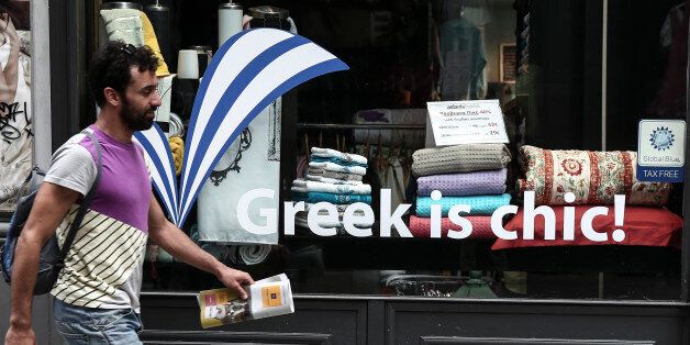 A man walks past a shop window in Athens, Greece, on Sunday, June 7, 2015. Greece cannot accept the