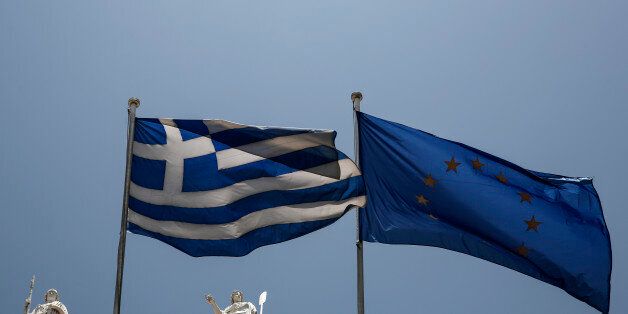 A Greek and a European Union flags flutter in front of statues of goddess Athena, left, and Nautilia, in front of Benaki museum in Athens, Greece, on Wednesday, June 17, 2015. Athens must pay 1.6 billion euros ($1.8 billion) off its debts at the end of the month to avoid a possible default and secure its cherished place among the 19 countries using the single currency.(AP Photo/Yorgos Karahalis)