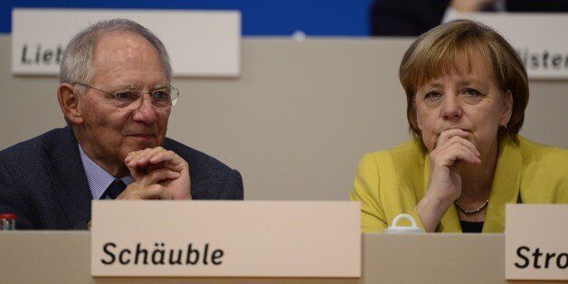 German Chancellor Angela Merkel (R) and German Finance Minister Wolfgang Schaeuble take part in the Christian Democratic Union (CDU) congress in Cologne, western Germany, on December 10, 2014. German Chancellor Angela Merkel was re-elected unopposed on December 9, 2014 as chief of her conservative party at a triumphant congress that celebrated her role as Europe's most powerful leader. AFP PHOTO / JOHN MACDOUGALL (Photo credit should read JOHN MACDOUGALL/AFP/Getty Images)