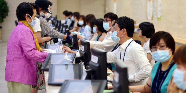 Hospital workers, right, wear masks as a precaution against Middle East Respiratory Syndrome virus as they talk with visitors at Chonnam University Hospital in Gwangju, South Korea, Monday, June 8, 2015. South Korea on Monday reported its sixth death from MERS as authorities were bolstering measures to stem the spread of the virus that has left dozens of people infected. (Yun Hyung-geun/Newsis via AP) KOREA OUT