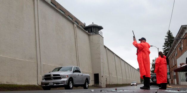 A state corrections officer monitors traffic passing Clinton Correctional Facility on Monday, June 8, 2015, in Dannemora, N.Y. Two murderers who escaped from the prison by cutting through steel walls and pipes remain on the loose Monday as authorities investigate how the inmates obtained the power tools used in the breakout. (AP Photo/Mike Groll)