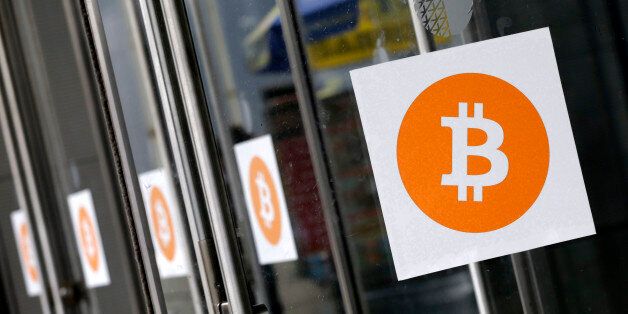 Bitcoin logos are displayed at the Inside Bitcoins conference and trade show, Monday, April 7, 2014 in New York. Bitcoin users exchange cash for digital money using online exchanges, then store it in a computer program that serves as a wallet. The program can transfer payments directly to merchants or individuals around the world, eliminating transaction fees and the need for bank or credit card information. (AP Photo/Mark Lennihan)