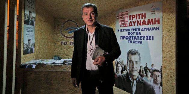 This photo taken on Wednesday, Jan. 21, 2015 shows Stavros Theodorakis, 51, leader of the political party To Potami (The River) poses for the photographers in front of a kiosk of his party central Athens. Greece goes to the polls on Sunday, Jan. 25, 2015 in a snap general election as the country was showing tentative signs of emerging from a deep financial crisis that has disturbed the eurozone. The vote, held more than a year early, has once more raised the specter of Grexit _ a Greek exit from Europeâs joint currency. The sign reads in Greek: ' Third power, the strong third power that will protect the country', referring to some poll results that suggest Potami could get the third place in the upcoming elections. (AP Photo/Lefteris Pitarakis)