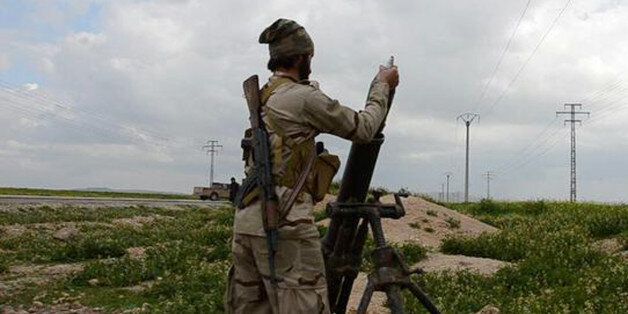 In this photo released on March 23, 2015, by a militant website, which has been verified and is consistent with other AP reporting, an Islamic State militant fires a mortar against Kurdish fighters, at the frontline near Tel Abyad town, northeast Syria. In contrast to the failures of the Iraqi army, in Syria Kurdish fighters are on the march against the Islamic State group, capturing towns and villages in an oil-rich swath of the country's northeast in recent days, under the cover of U.S.-led ai