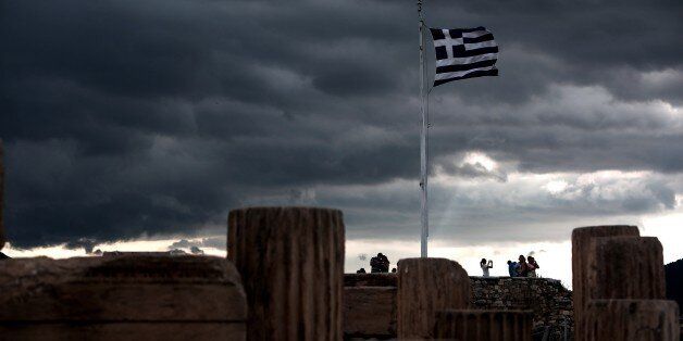A Greek flag waves in the breeze at Acropolis hill, in Athens on June 5, 2015. Greece bought time in debt crisis negotiations with official creditors when it moved to bundle four looming IMF loan payments into one, to be paid by the end of June. The rare move, permitted by the International Monetary Fund only once before, allowed Athens to avoid a Friday deadline to remit about 300 million euros ($340 million) to the crisis lender, as it weighs the newest proposal from its IMF, European Commission and European Central Bank creditors.AFP PHOTO / Angelos Tzortzinis (Photo credit should read ANGELOS TZORTZINIS/AFP/Getty Images)