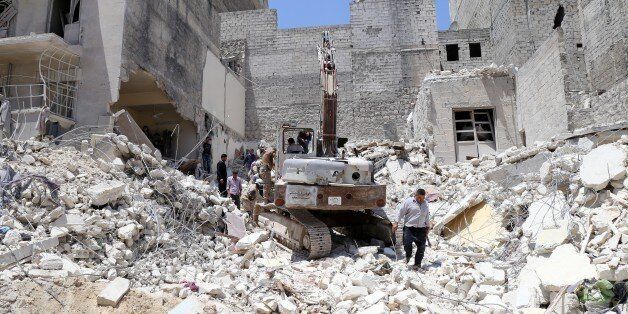 People inspect the rubble of collapsed buildings following a reported airstrike by government forces on May 24, 2015, in the rebel-held al-Sukari neighborhood of the northern city of Aleppo. AFP PHOTO / BARAA AL-HALABI (Photo credit should read BARAA AL-HALABI/AFP/Getty Images)