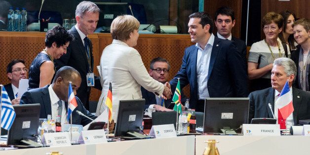 Greek Prime Minister Alexis Tsipras, center right, shakes hands with German Chancellor Angela Merkel, center left, at the start of a round table meeting at the EU-CELAC summit in Brussels on Wednesday, June 10, 2015. Greece's prime minister was hoping to meet with the leaders of Germany and France in Brussels Wednesday, in the latest effort to break a bailout negotiation deadlock that has revived fears his country could default and drop out of the euro. (AP Photo/Geert Vanden Wijngaert)