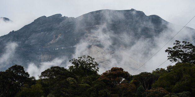 Malaysia's Mount Kinabalu is seen among mists from the Timpohon gate check point a day after the earthquake in Kundasang, a town in the district of Ranau on June 6, 2015. A strong earthquake that jolted Malaysia's Mount Kinabalu killed at least 11 people and left another 8 missing, an official said, as authorities continued to search for survivors on Southeast Asia's highest peak. AFP PHOTO / MOHD RASFAN (Photo credit should read MOHD RASFAN/AFP/Getty Images)