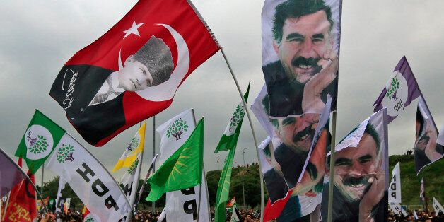 Supporters of the pro-Kurdish Peoples' Democratic Party, (HDP) wave a flag, top left, with Turkish Republic founder Mustafa Kemal Ataturk, and others with pictures of imprisoned Kurdish rebel leader Abdullah Ocalan, during a rally in Istanbul, Turkey, Monday, June 8, 2015, a day after the elections. The biggest change from Turkey's previous parliament is the ascendancy of the People's Democratic Party, a socially liberal force rooted in the Kurdish nationalism of Turkey's southeast. It attracted more than 12 percent of votes, breaching the minimum threshold of 10 percent. Turkey's President Recep Tayyip Erdogan's long-ruling Justice and Development Party(AKP), has suffered surprisingly strong losses in parliament that will force it to seek a coalition partner for the next government. (AP Photo/Lefteris Pitarakis)