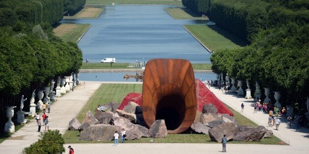 'Dirty Corner', a 2011 Cor-Ten steel, earth and mixed media monumental artwork by British contemporary artist of Indian origin Anish Kapoor, is displayed in the gardens of the Chateau de Versailles, in Versailles on June 5, 2015, as part of 'Kapoor Versailles', an exhibition of Kapoor's work that runs through June 9-November 1, 2015. AFP PHOTO / STEPHANE DE SAKUTIN --RESTRICTED TO EDITORIAL USE, MANDATORY MENTION OF THE ARTIST UPON PUBLICATION, TO ILLUSTRATE THE EVENT AS SPECIFIED IN THE CAPTION