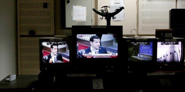 Greek Prime Minister Alexis Tsipras is seen on a TV monitor (C) at the control room during the news broadcast of state television ERT in Athens on June 11, 2015. Greece's public broadcaster ERT came back on the air on Thursday, exactly two years after it was shut down by the previous government, which accused it of being wasteful and mismanaged. AFP PHOTO / ANGELOS TZORTZINIS (Photo credit should read ANGELOS TZORTZINIS/AFP/Getty Images)