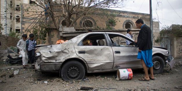 People stand inspect a car damaged from Saudi-led airstrikes in Sanaa, Yemen, Wednesday, May 27, 2015. In a new report Wednesday, World Health Organization Chief Margaret Chan said that Yemen's conflict has left up to 2,000 people dead and 8,000 wounded, including hundreds of women and children. She did not specify how many of the dead were civilian. (AP Photo/Hani Mohammed)