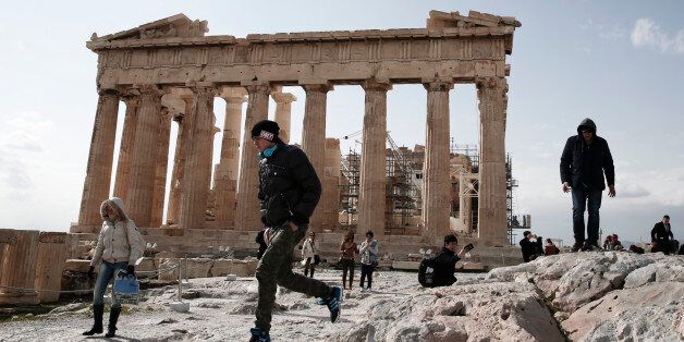 A tourist jumps in front of the ancient Parthenon temple at the Acropolis hill, in Athens, on Tuesday, Feb. 17, 2015. Greek shares led a European retreat Tuesday as investors reacted negatively to the breakdown in talks between Greece and its creditors in the 19-nation eurozone over the country's attempt to renegotiate its financial bailout. (AP Photo/Petros Giannakouris)