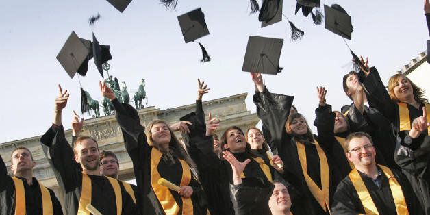Graduates of the private 'International Business School Berlin' (IBS) throw their doctoral caps in the air as they pose for a family picture 31 January 2008 in front of the Brandenburg Gate in Berlin. The young men and women finished their studies in international management. AFP PHOTO DDP/MICHAEL KAPPELER GERMANY OUT (Photo credit should read MICHAEL KAPPELER/AFP/Getty Images)