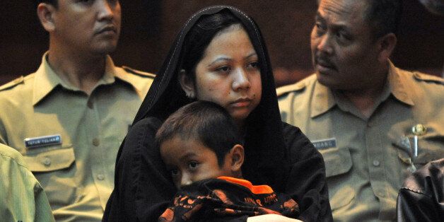 Γυναίκα από την Ινδονησία η οποία η οποία καταδικάστηκε σε θάνατο στη Σαουδική Αραβία. Κρατά στα χέρια της το τον γιο της ενώ οι αρχές την παραδίδουν στις αρχές της Τζακάρτα, αφού η κυβέρνηση της χώρας πλήρωσε 534.884 δολάρια ΗΠΑ στη Σ.Αραβία για να μην προχωρήσει με την εκτέλεσ