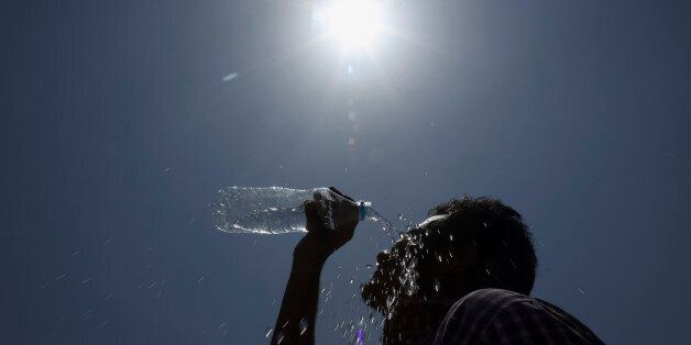 An Indian man pours water on his face during a hot summer day in Hyderabad, India, Sunday, May 24, 2015. About 230 people have died since mid-April in a heat wave sweeping two southeast Indian states, Andhra Pradesh and Telangana, officials said Saturday. Day temperatures in Telangana's Khammam district soared to more than 48 degrees Celsius (118 Fahrenheit) on Saturday. (AP Photo/Mahesh Kumar A.)