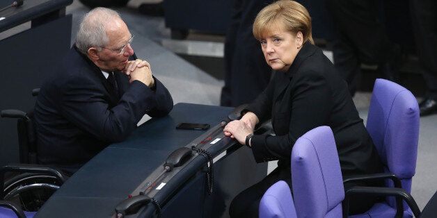 BERLIN, GERMANY - DECEMBER 17: German Chancellor Angela Merkel (R) and Finance Minister Wolfgang Schaeuble chat during a vote at the Bundestag over her third term as chancellor during ceremonies in which the new German government will be sworn in on December 17, 2013 in Berlin, Germany. The new government is a coalition between the German Christian Democrats (CDU), the Bavarian Christian Democrats (CSU) and German Social Democrats (SPD) following federal elections held in September. (Photo by Sean Gallup/Getty Images)