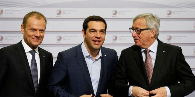 European Commission President Jean-Claude Juncker, right, and Greek Prime Minister Alexis Tsipras, center, button their jackets as the stand with European Council President Donald Tusk during arrivals at the Eastern Partnership summit in Riga, on Friday, May 22, 2015. EU leaders gather for a second day of meetings with six post-communist nations to discuss various issues, including enlargement, the economy and Ukraine. (AP Photo/Mindaugas Kulbis)