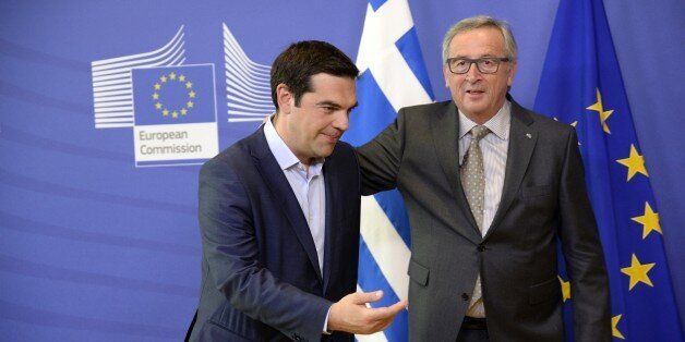 Prime Minister of Greece Alexis Tsipras (L) walks with European Union Commission President Jean-Claude Juncker prior to their meeting at the European Union Commission headquarter in Brussels, on June 3, 2015. Greek Prime Minister Alexis Tsipras heads for last-ditch talks with European Commission chief Jean-Claude Juncker in Brussels to seal a desperately-needed bailout deal despite pessimism from hardline Germany. AFP PHOTO / THIERRY CHARLIER (Photo credit should read THIERRY CHARLIER/AFP