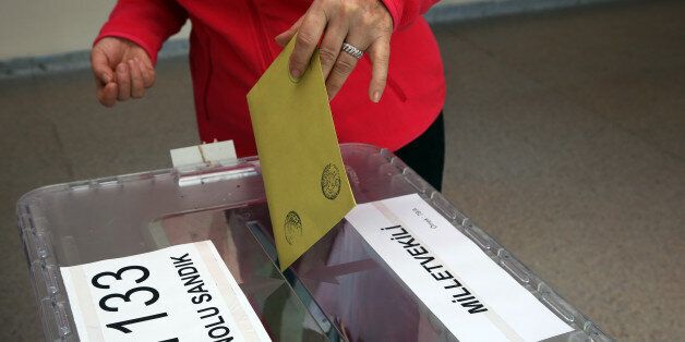 A Turkish woman casts her vote at a polling station in a primary school in Ankara, Turkey, Sunday, June 7, 2015. Turkey is holding Sunday a general election and approximately 56 million Turkish voters are eligible to cast their ballots to elect 550 members of national parliament. (AP Photo/Burhan Ozbilici)