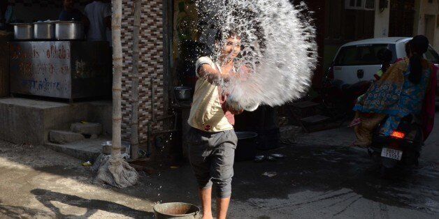 An Indian worker throws water outside a resteraunt in Amritsar on May 26, 2015, in an attempt to keep the pavement cool on a hot day. At least 800 people have died in a major heatwave that has swept across India, melting roads in New Delhi as temperatures neared 50 degrees Celsius (122 Fahrenheit). AFP PHOTO/NARINDER NANU (Photo credit should read NARINDER NANU/AFP/Getty Images)