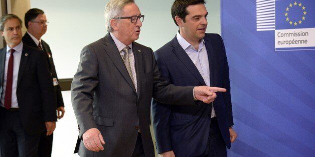 Prime Minister of Greece Alexis Tsipras (L) walks with European Union Commission President Jean-Claude Juncker prior to their meeting at the European Union Commission headquarter in Brussels, on June 3, 2015. Greek Prime Minister Alexis Tsipras heads for last-ditch talks with European Commission chief Jean-Claude Juncker in Brussels to seal a desperately-needed bailout deal despite pessimism from hardline Germany. AFP PHOTO / THIERRY CHARLIER (Photo credit should read THIERRY CHARLIER/AFP