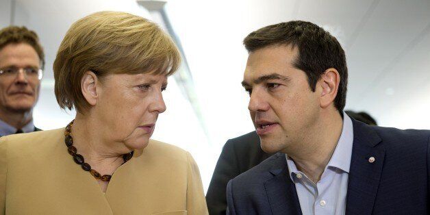 German chancellor Angela Merkel (L) talks with Greek prime minister Alexis Tsipras at the begining of the second day of the fourth European Union (EU) eastern Partnership Summit in Riga, on May 22, 2015 as Latvia holds the rotating presidency of the EU Council. EU leaders and their counterparts from Ukraine and five ex-Soviet states hold a summit focused on bolstering their ties, an initiative that has been undermined by Russia's intervention in Ukraine. AFP PHOTO ALAIN JOCARD (Photo cre