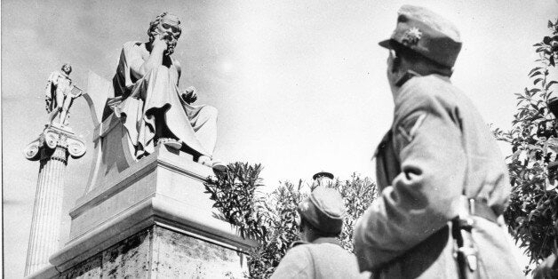 German troopers in their field grey uniforms look up at two ancient Greek statues on the Acropolis in Athens, Greece on June 15, 1941 during World War II. The statue in front is of Greek philosopher Socrates. (AP Photo)