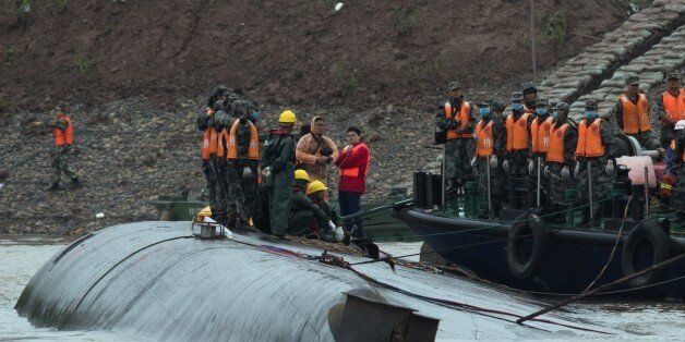 Rescue workers are seen on the hull of a capsized passenger ship Dongfangzhixing or 'Eastern Star' in the Yangtze river at Jianli in China's Hubei province on June 3, 2015. Relatives of more than 400 people missing after a cruise ship capsized on China's Yangtze river were hoping for a 'miracle' June 3, as authorities said they were racing against time to find any survivors. AFP PHOTO / JOHANNES EISELE (Photo credit should read JOHANNES EISELE/AFP/Getty Images)
