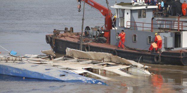This photo taken on June 5, 2015 shows rescuers working to raise the sunken ship 'Eastern Star' at the disaster site in Jianli, central China's Hubei province. A total of 396 people have been confirmed dead after a cruise ship capsized in China, state media said, making it the country's worst shipping disaster in nearly 70 years. AFP PHOTO CHINA OUT (Photo credit should read STR/AFP/Getty Images)