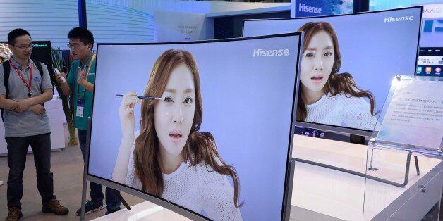 An exhibitor (R) demonstrates Hisense ULED televisions to a visitor on the last day of the first Consumer Electronics Show (CES) in Asia in Shanghai on May 27, 2015. More than 200 technology companies from 15 countries around the world are showcasing their consumer technology innovations at CES Asia which takes place from May 25 to 27. AFP PHOTO CHINA OUT (Photo credit should read STR/AFP/Getty Images)