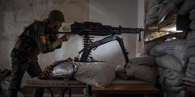 A Russia-backed rebel aims a machine gun on the outskirts of Donetsk, eastern Ukraine, Tuesday, May 26, 2015. The situation in eastern Ukraine has remained tense and skirmishes between Ukrainian forces and Russia-backed separatists have continued despite a cease-fire signed in February. (AP Photo/Mstyslav Chernov)