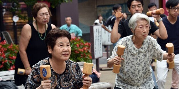 Elderly residents work out with wooden dumb-bells in the grounds of a temple in Tokyo on September 15, 2014 to celebrate Japan's Respect-for-the-Aged-Day. The number of people aged 65 or older in Japan is at a record 32.96 million, accounting for an all-time high of 25.9 percent of the nation's total population, the government announced. AFP PHOTO / Yoshikazu TSUNO (Photo credit should read YOSHIKAZU TSUNO/AFP/Getty Images)