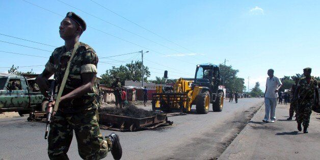 Members of the military escort a forklift as barricades erected by demonstrators are removed in the Cibitoke district of Bujumbura on May 10, 2015. Burundi's security forces began clearing barricades in the capital Bujumbura on May 10 after the government ordered an immediate end to protests against President Pierre Nkurunziza's controversial bid for a third term. AFP PHOTO / AYMERIC VINCENOT (Photo credit should read AYMERIC VINCENOT/AFP/Getty Images)