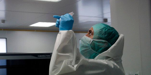 A forensic scientist of the Criminal Research Institute of the National Gendarmerie (IRCGN), collects DNA taken from the body parts of people involved in the crash of Germanwings jetliner, in Pontoise, outside Paris, France, Monday, March 30, 2015. The process of identifying the victims of Germanwings crash has now entered its active phase, but the families will still have to wait months to find out if their loved ones are among the bodies found. (AP Photo/Christophe Ena, Pool)
